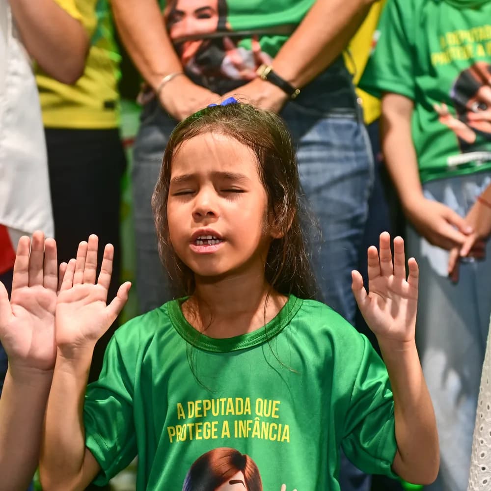 Criança com as mãos levantadas, camiseta 'a deputada que protege a infância'